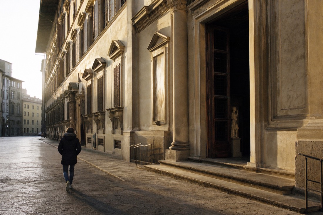 Early morning light on the pale stone entrance of the Accademia Gallery on Via Ricasoli in Florence with the street still empty