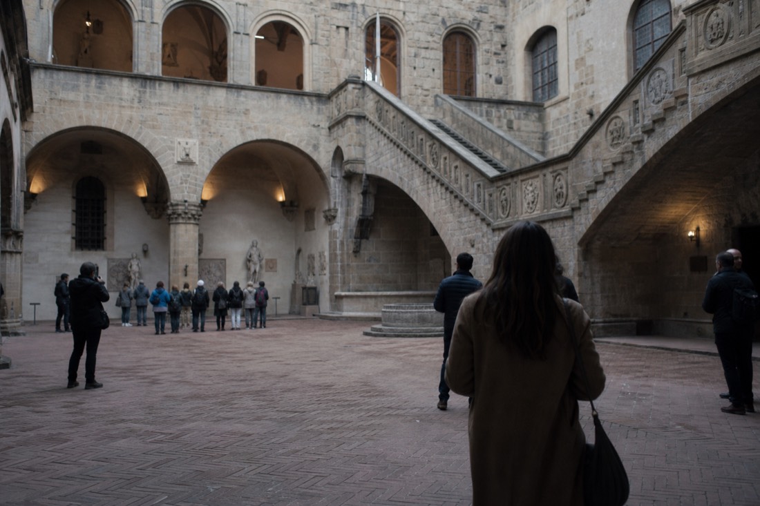 A stone Renaissance palace courtyard with an open loggia and staircase, the Bargello museum in Florence, soft daylight