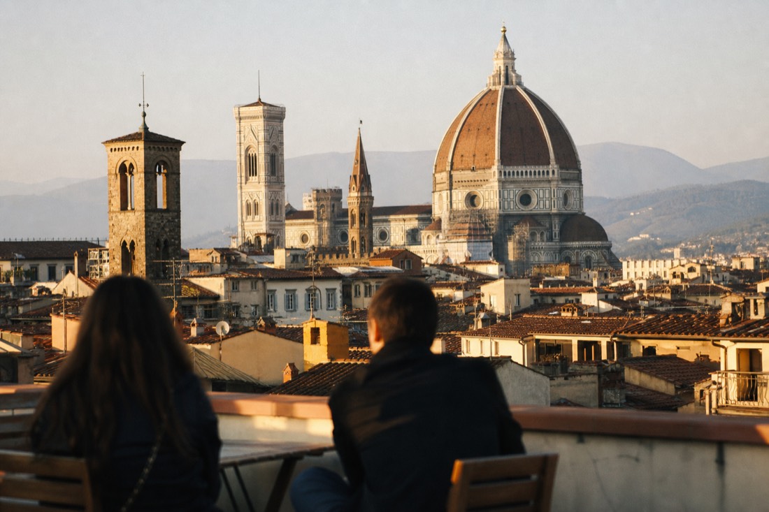 The red-tiled Brunelleschi dome of Florence Cathedral seen from a rooftop in warm light