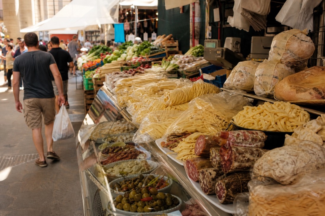 Fresh pasta, cured meats and produce on a stall inside a Florence food market hall