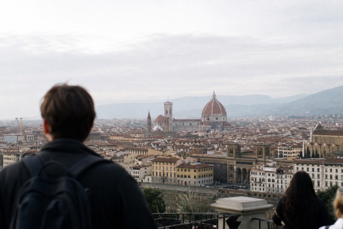 Sunrise over the terracotta rooftops of Florence with the Duomo dome rising above quiet streets