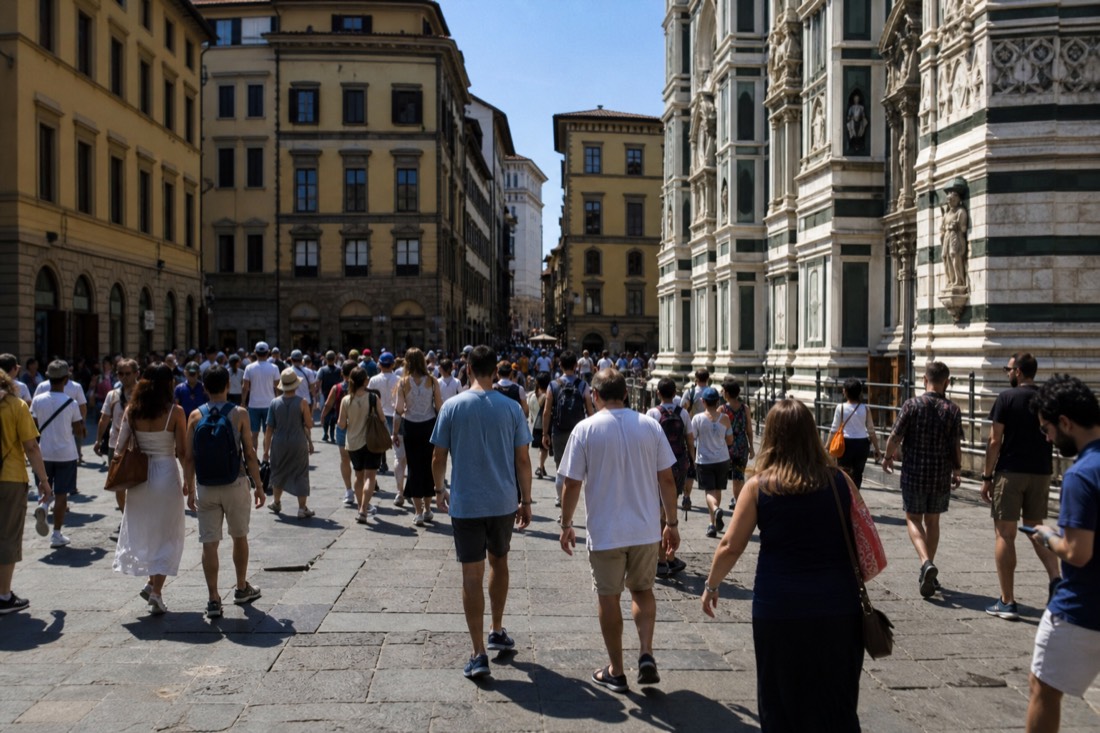 Crowded Piazza San Marco in Florence on a holiday morning with people crossing toward Via Ricasoli