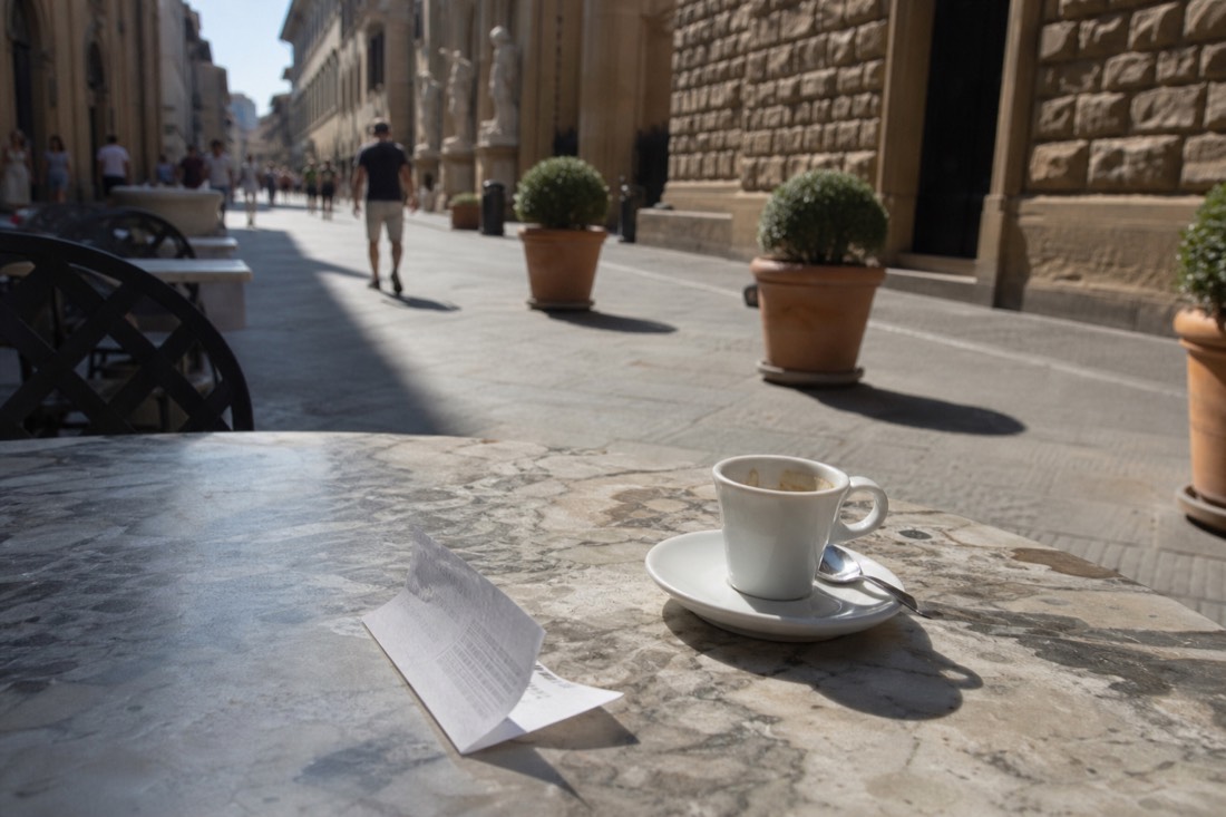 A paper museum ticket and small espresso cup on a marble cafe table on Via Ricasoli near the Accademia Gallery in Florence