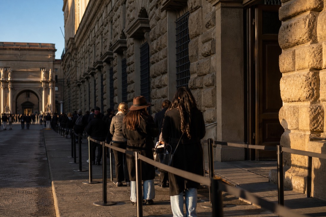 Queue barriers and waiting visitors along the stone facade of the Accademia Gallery entrance on Via Ricasoli
