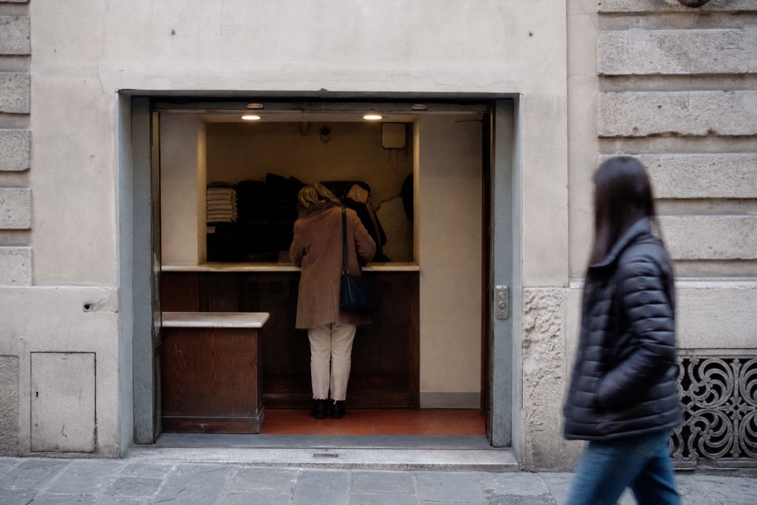 A small ground-floor ticket and storage office on Via Ricasoli in Florence with bags stacked behind the counter