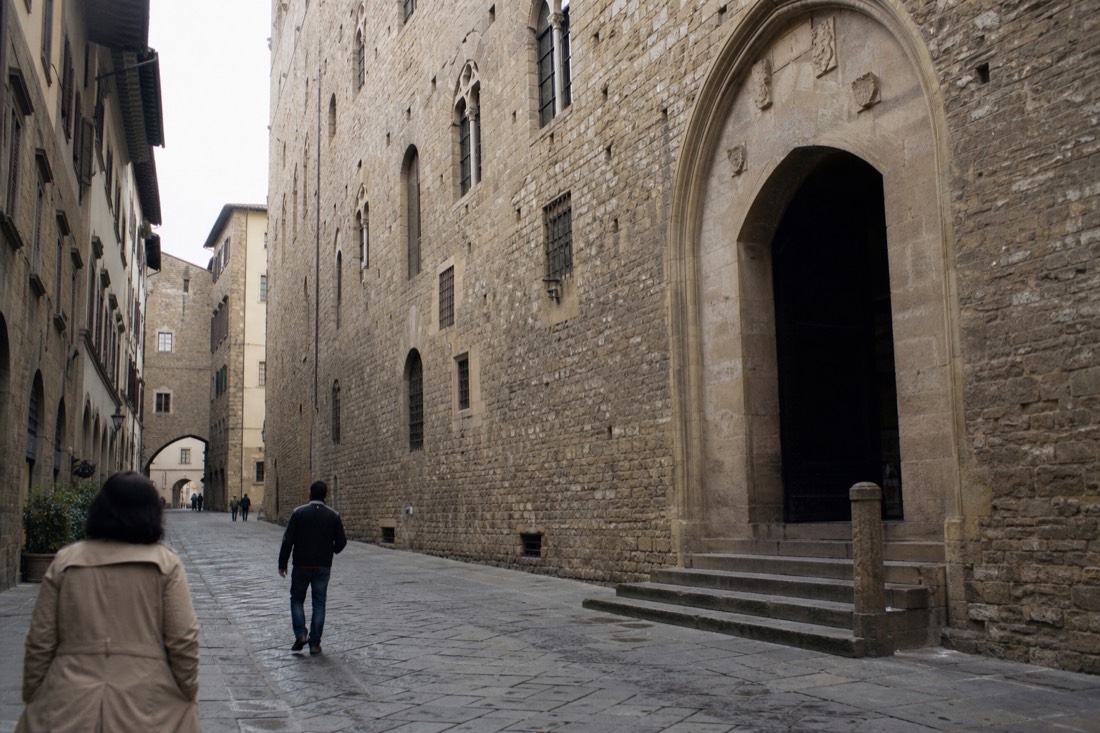 The stone facade and arched doorway of the Bargello museum on a quiet Florence street in morning light